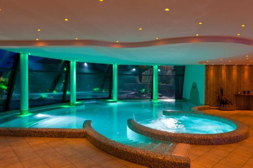 a large swimming pool in a building with a fountain at La Quiete Resort in Romeno