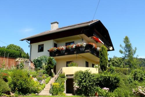 una casa con flores en el balcón en Ferienwohnung Eichler, en Feldkirchen in Kärnten