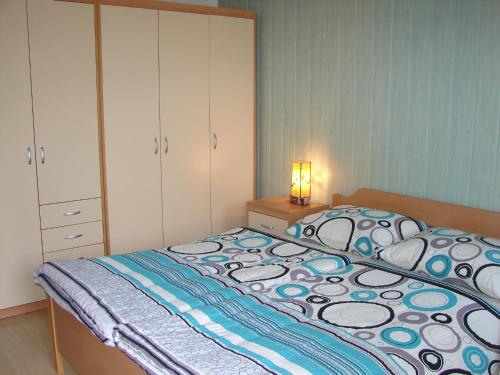 a bedroom with a bed and a dresser and a lamp at Apartma Veverin in Lokve