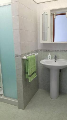 a bathroom with a sink and a toilet and a mirror at Il Girasole Alloggio in Fluminimaggiore