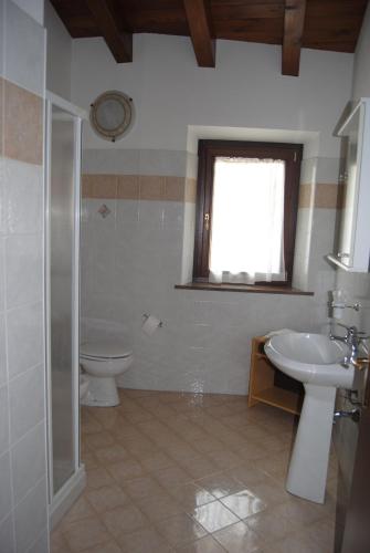 フィウマルボにあるAlbergo Val di Luceのバスルーム(洗面台、トイレ付)、窓が備わります。