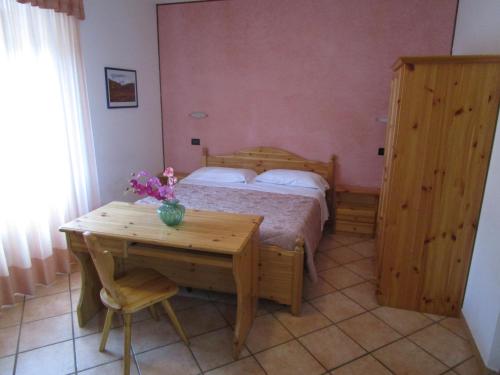 フィウマルボにあるAlbergo Val di Luceのベッドルーム1室(ベッド1台、デスク、テーブル付)