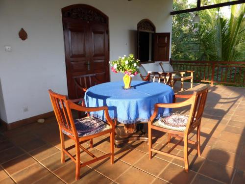 un tavolo blu con sedie e un vaso di fiori sopra di Villa Sunrise a Tangalle
