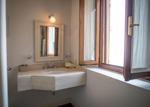 a bathroom with a sink and a mirror and a window at Castello Di Mornico Losana in Mornico Losana