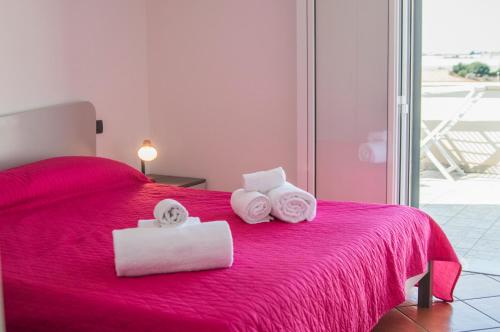 プンタ・セッカにあるMatisse Beachのベッドルーム1室(赤いベッド1台、タオル付)