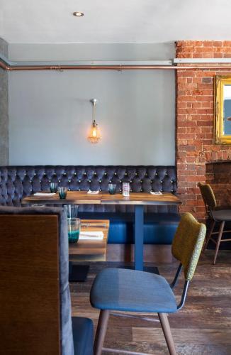 a dining room with a bench and a chair at The Queen's Inn in Hawkhurst