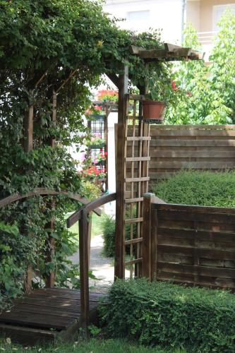 a garden with a wooden gate and a ladder at Logis Hôtel Beauséjour in Chauvigny