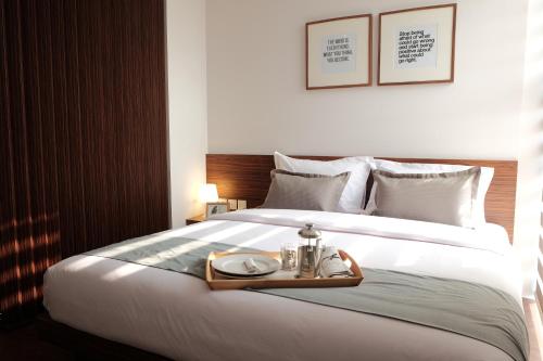 a bed with a tray with a plate on it at FLAT06.Tendean in Jakarta