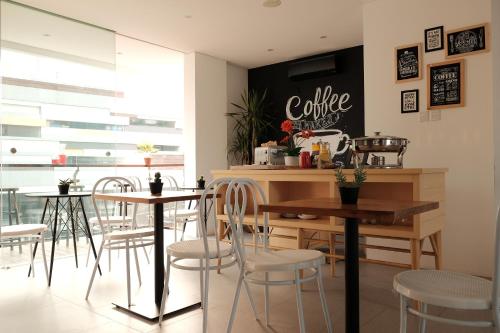 a restaurant with tables and chairs and a chalkboard on the wall at FLAT06.Tendean in Jakarta
