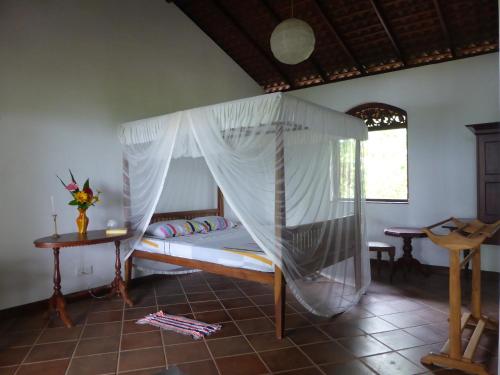 a bedroom with a bed with a mosquito net at Villa Sunrise in Tangalle