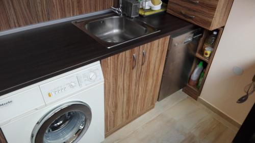 a kitchen with a washing machine and a sink at Luxury Apartment Uzunov in Hisarya