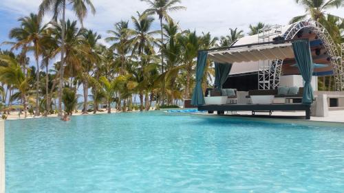 a view of a resort swimming pool with palm trees at Bavaro Green in Punta Cana