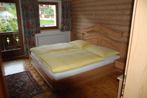 een slaapkamer met een bed in een houten kamer bij Ferienwohnungen Falger in Berwang