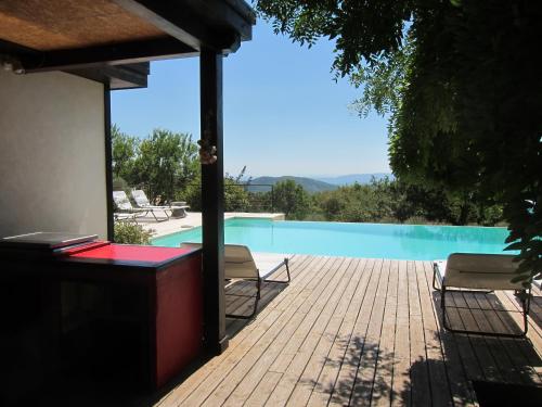 une piscine avec deux chaises à côté d'une maison dans l'établissement Le Jas du Boeuf, à Cruis