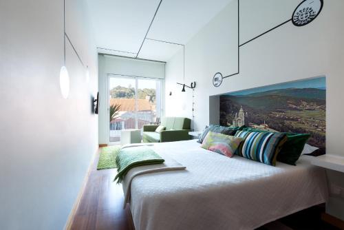 a bedroom with a large bed and a large window at Pensao O Laranjeira in Viana do Castelo