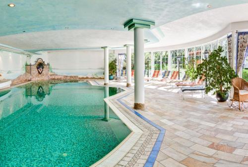 a swimming pool in a building with a pool at Hotel Lumberger Hof in Grän