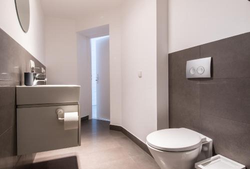 a bathroom with a white toilet and a sink at Apartament przy OFF Piotrkowska in Łódź