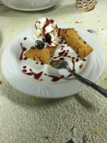 a white plate with a piece of cake and whipped cream at Corte Ca' Bosco in Castello di Serravalle