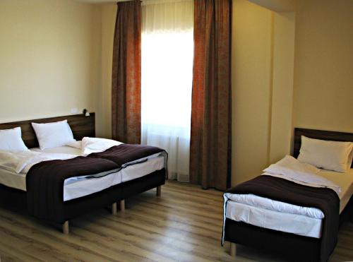 dwa łóżka w pokoju z oknem w obiekcie Hotel Czerniewski w Warszawie