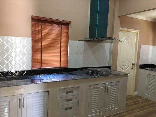 a kitchen with white cabinets and a counter top at Sangchan Garden at Kaeng Krachan in Kaeng Krachan
