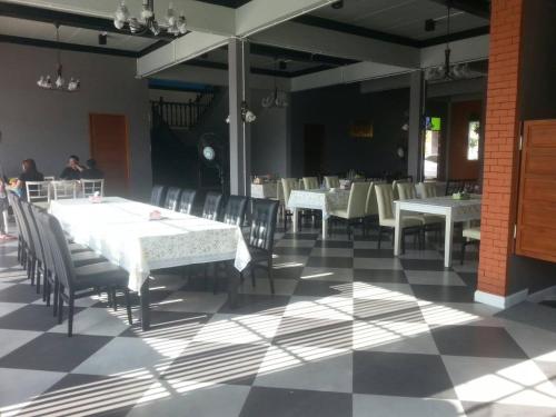 a dining room with white tables and chairs at Sangchan Garden at Kaeng Krachan in Kaeng Krachan