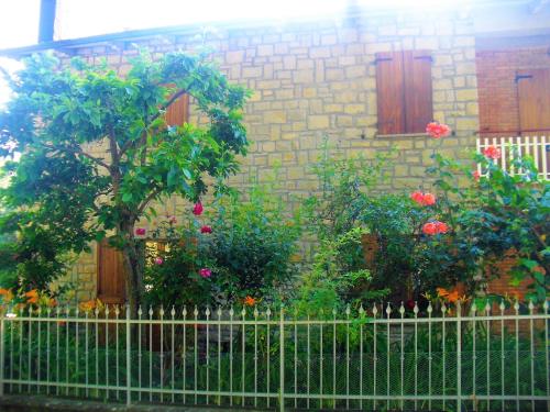 une clôture devant un bâtiment fleuri dans l'établissement Appartamento Degli Dei (Affittacamere), à Madonna di Fornelli