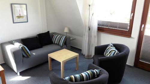 un soggiorno con divano, 2 sedie e tavolo di Stadtmitte a Westerland