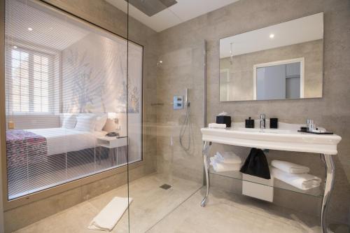 1 cama y baño con ducha y lavabo. en Palais Saleya Boutique hôtel, en Niza