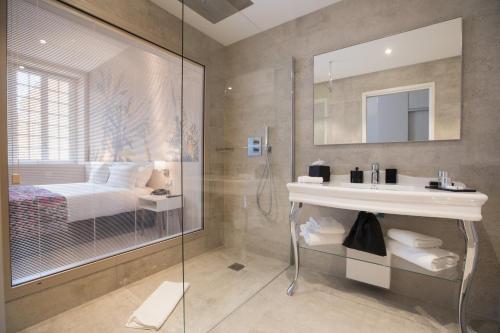 a bathroom with a shower and a sink and a bed at Palais Saleya Boutique Hôtel in Nice