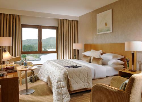 a hotel room with a bed and a large window at Sneem Hotel in Sneem