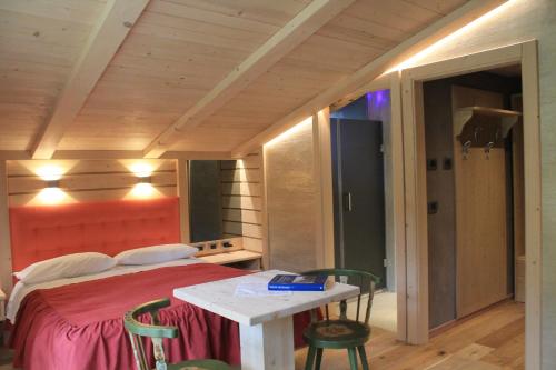 a bedroom with a bed and a table with chairs at Albergo Chalet Lago Antorno in Misurina