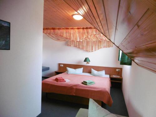 Hotel & Pension Aßmann في Hochkirch: غرفة نوم مع سرير مع لحاف احمر