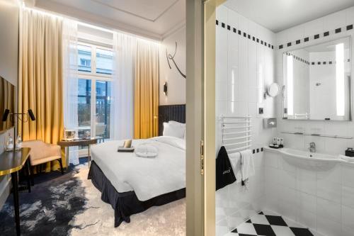 a hotel room with a bed and a bathroom at Century Old Town Prague - MGallery Collection in Prague