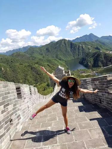 a woman standing on a wall with her arms out at Tianjin Jixian Libo Family Farmstay in Jizhou
