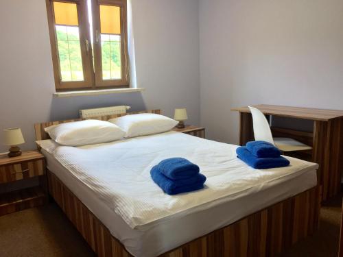 a bedroom with a bed with two blue towels on it at Da Vinci in Chęciny