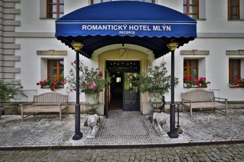 a building with a blue umbrella in front of a building at Romantic Hotel Mlýn Karlstejn in Karlštejn