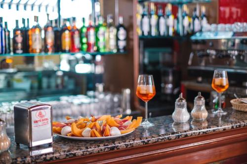 a plate of food on a bar with two glasses of wine at Hotel Firenze 2000 in Florence