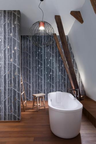 a bathroom with a white bath tub and a ladder at Relais & Châteaux Hotel Quadrille - Adults Only in Gdynia