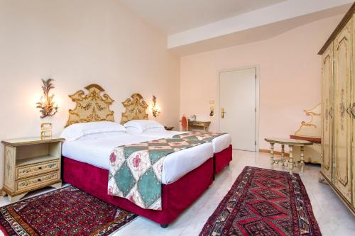 a bedroom with a large bed and a table at Hotel Biasutti in Venice-Lido