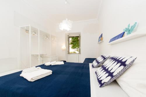 a white room with a blue bed with towels on it at Ottaviano Exclusive Maison in Rome