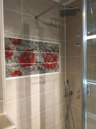 La salle de bains est pourvue d'une douche et d'une peinture murale. dans l'établissement Blue Beach Studio, au Cap d'Agde