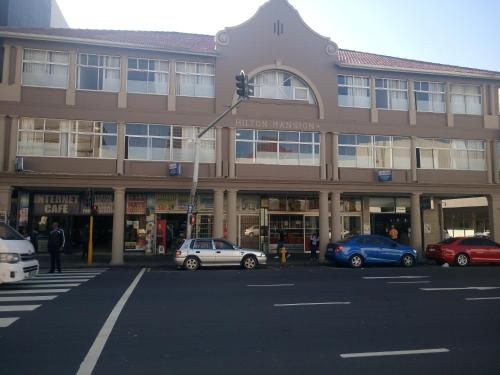 Un gran edificio con coches aparcados delante. en The Union Hotel, en Durban