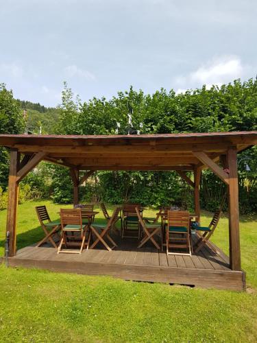 a wooden gazebo with a table and chairs at BLUE PENSiON in Svoboda nad Úpou