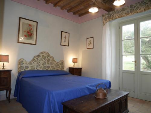 a bedroom with a bed with a blue bedspread at Agriturismo Podere Gianmaria in Castiglioncello