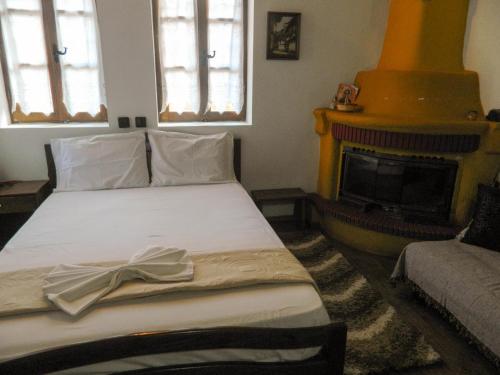 a bedroom with a bed and a fireplace at Guesthouse Klearchos in Palaios Panteleimon