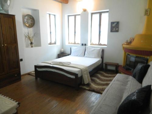 a bedroom with a bed and a fireplace at Guesthouse Klearchos in Palaios Panteleimon