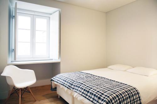 ein Schlafzimmer mit einem Bett, einem Stuhl und einem Fenster in der Unterkunft Boavista Bike Apartment in Lissabon