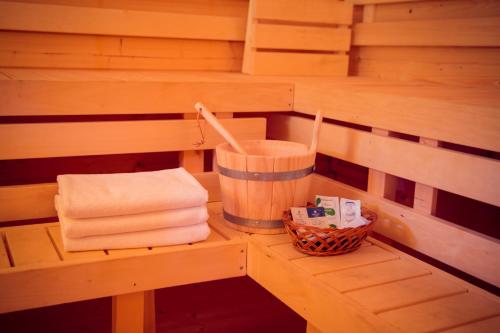 a sauna with towels and a basket on a shelf at Seepark Wolfswinkel in Storkow