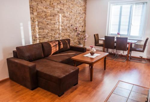 - un salon avec un canapé brun et une table dans l'établissement Vila Magnolie, à Luhačovice