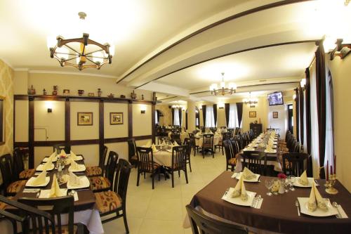 a dining room with tables and chairs in a restaurant at Hotel Victoria in Borşa